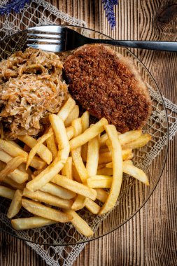 Patates kızartması ve haşlanmış lahana ile servis edilen domuz pirzolası. Seçici odak.