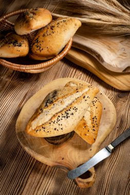 Köy ahşap bir masada taze ekmek ruloları. Kahvaltı için fırından taze ekmek ruloları..