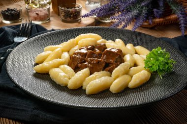 Soslu sığır eti yahnisi, patates köftesiyle servis edilir..