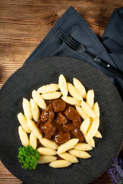 Soslu sığır eti yahnisi, patates köftesiyle servis edilir..