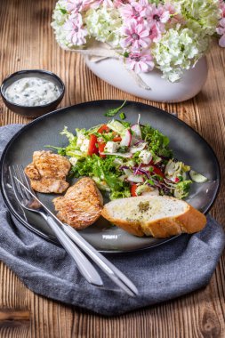 Izgara tavuk eti ve taze sebze salatası, marul, roka, turp, salatalık ve domates. Diyet yemek..