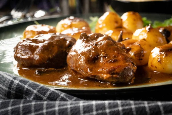 Traditional German braised pork cheeks in brown sauce with mushroom served with silesian dumplings.