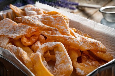 Faworki (melek kanatları) pudra şekeri serpiştirilmiş - geleneksel Polonya karnavalı lezzeti