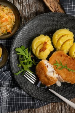 Haşlanmış patates ve sebze salatasıyla servis edilen kızarmış morina filetosu..