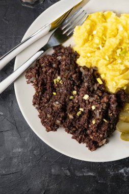 Kızarmış puding, patates püresi ve salatalık turşusu..