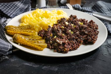 Kızarmış puding, patates püresi ve salatalık turşusu..