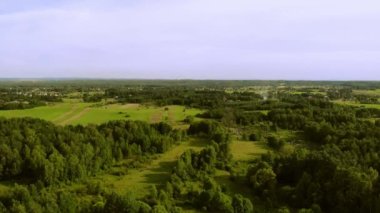 Batan güneşin ışığında çayırlar ve ormanlar. Yukarıdan görüldü..