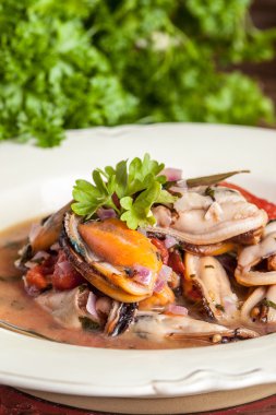 Pişmiş domates soslu midye.