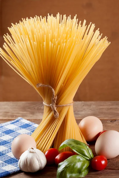 Okokt italienska torkade spagetti bundna med sträng. — Stockfoto