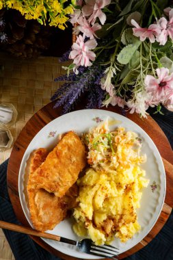 Kızarmış morina filetosu haşlanmış patates ve sebze salatasıyla servis ediliyor...