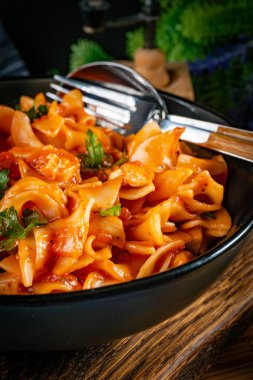 Domates soslu erişteli tavuk parçaları. Sığ alan derinliği.