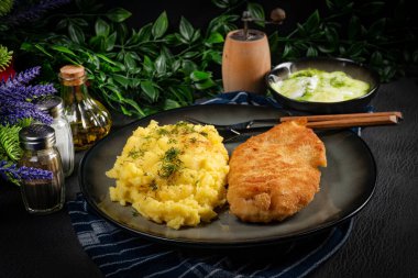 Kızarmış tavuk göğsü fileto haşlanmış patates ve salatalık dilimleri ile servis edilir..