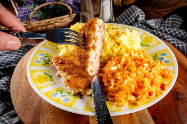 Patates püresi ve salatayla servis edilen kıymalı tavuk pirzolası..