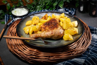 Akşam yemeğinde kızarmış patatesle servis edilen kahverengi derili iştah açıcı tavuk budu..