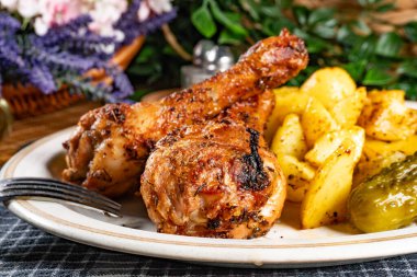 Fırında tavuk budu ve patates. Sığ alan derinliği. 