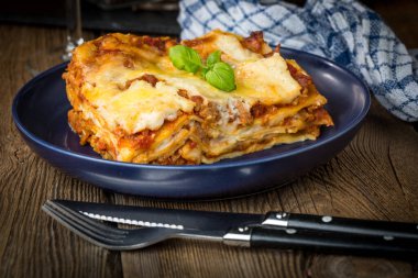 Kırmızı şarap ile lezzetli sıcak lazanya parçası. Küçük alan derinliği.