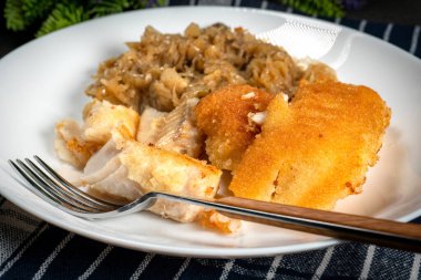 Lahana ve mantarla servis edilen kızarmış balık filetosu..