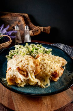 Peynir battaniyesinin altına doldurulmuş krep. Seçici odak.