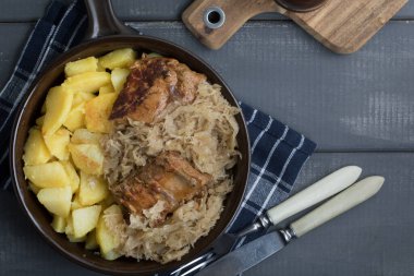 Kızarmış patatesle servis edilen lahana turşulu pirzola..