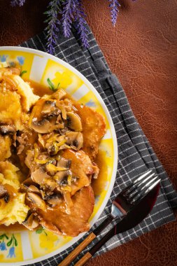 Mantarlı domuz eti parçaları, patates püresi ile servis edilir..