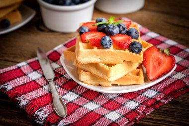 Bir tabak meyve ile waffle yığını. Küçük alan derinliği.