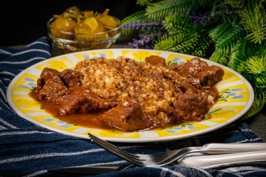 Acı sosla doldurulmuş bulgur groats ile servis edilen sığır kebabı. Sığ alan derinliği.