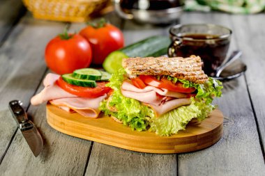 Sandviç ile jambon, salatalık, domates, marul, dolum üç dilim kızarmış ekmek arasında iki kat ile.