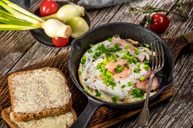 Ahşap arka planda jambonlu sahanda yumurta..