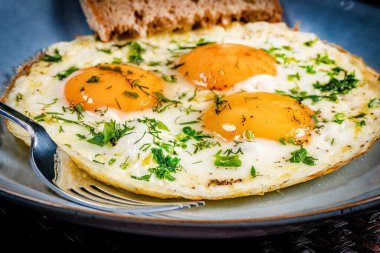 Tabakta bir dilim ekmekle sahanda yumurta. Sığ alan derinliği.