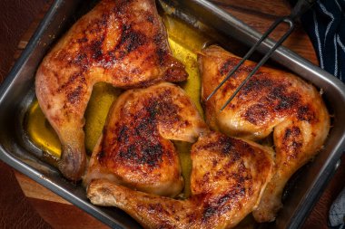 Ahşap mutfak tahtasının üzerinde pişirilmiş tavuk budu..