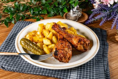 Fırında tavuk budu ve patates. Sığ alan derinliği.