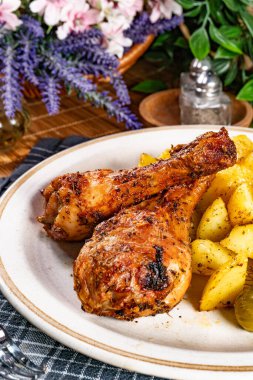 Fırında tavuk budu ve patates. Sığ alan derinliği.