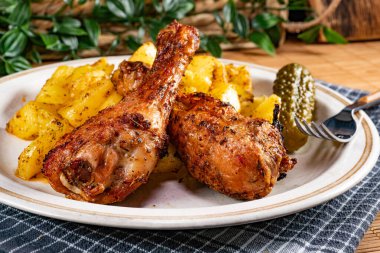 Fırında tavuk budu ve patates. Sığ alan derinliği.