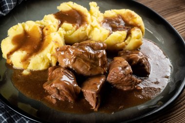 Sos ve patates püresiyle servis edilen haşlanmış hindi eti. Sığ alan derinliği.