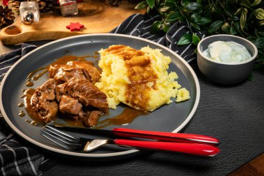 Sos ve patates püresiyle servis edilen haşlanmış hindi eti. Sığ alan derinliği.