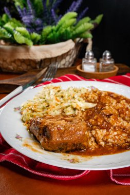 Baharatlı soslu haşlanmış domuz eti, bulgur ve lahana turşusu salatası. Sığ alan derinliği.