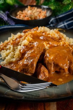 Kendi soslu haşlanmış domuz boyunlu arpa ve salatayla servis ediliyor. Sığ alan derinliği.