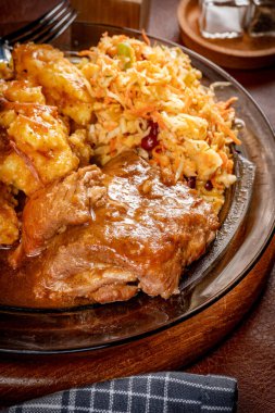 Patates püresi ve salatayla servis edilen acılı soslu domuz pirzolası. Sığ alan derinliği.