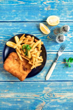 Tabakta patates kızartması olan kızarmış morina balığı. Üst görünüm.