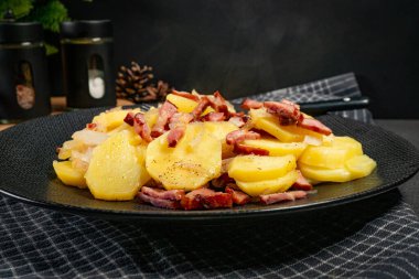 Tütsülenmiş domuz pastırması, sosis ve soğanlı haşlanmış patates. Geleneksel bir cilası..