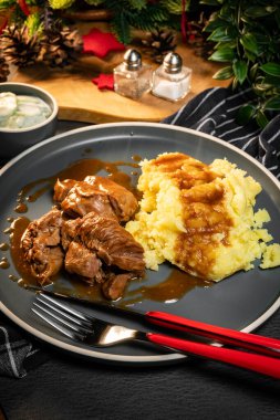 Sos ve patates püresiyle servis edilen haşlanmış hindi eti. Sığ alan derinliği.