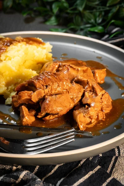 Sos ve patates püresiyle servis edilen haşlanmış hindi eti. Sığ alan derinliği.