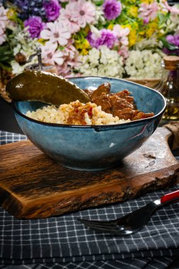 Güveçte bulgur ve salatalık turşusu ile servis edilir..