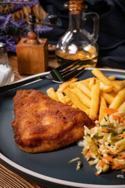 Kızarmış balık fileto, yanında patates kızartması ve salata..