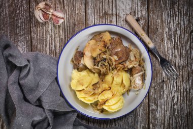 Kızarmış ciğer, soğan ve elma haşlanmış patates ve salatalık turşusu ile servis edilir. Üst görünüm.