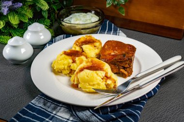 Patates püresi ve salatayla servis edilen acılı soslu domuz pirzolası. Sığ alan derinliği.