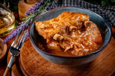 Kavanozda baharatlı soslu domuz pirzolası. Sığ alan derinliği.