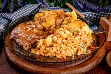 Patates püresi ve salatayla servis edilen acılı soslu domuz pirzolası. Sığ alan derinliği.