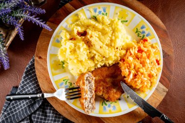 Patates püresi ve salatayla servis edilen kıymalı tavuk pirzolası..