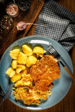 Patates ve salatayla servis edilen domuz boyunlu pirzola. Sığ alan derinliği.